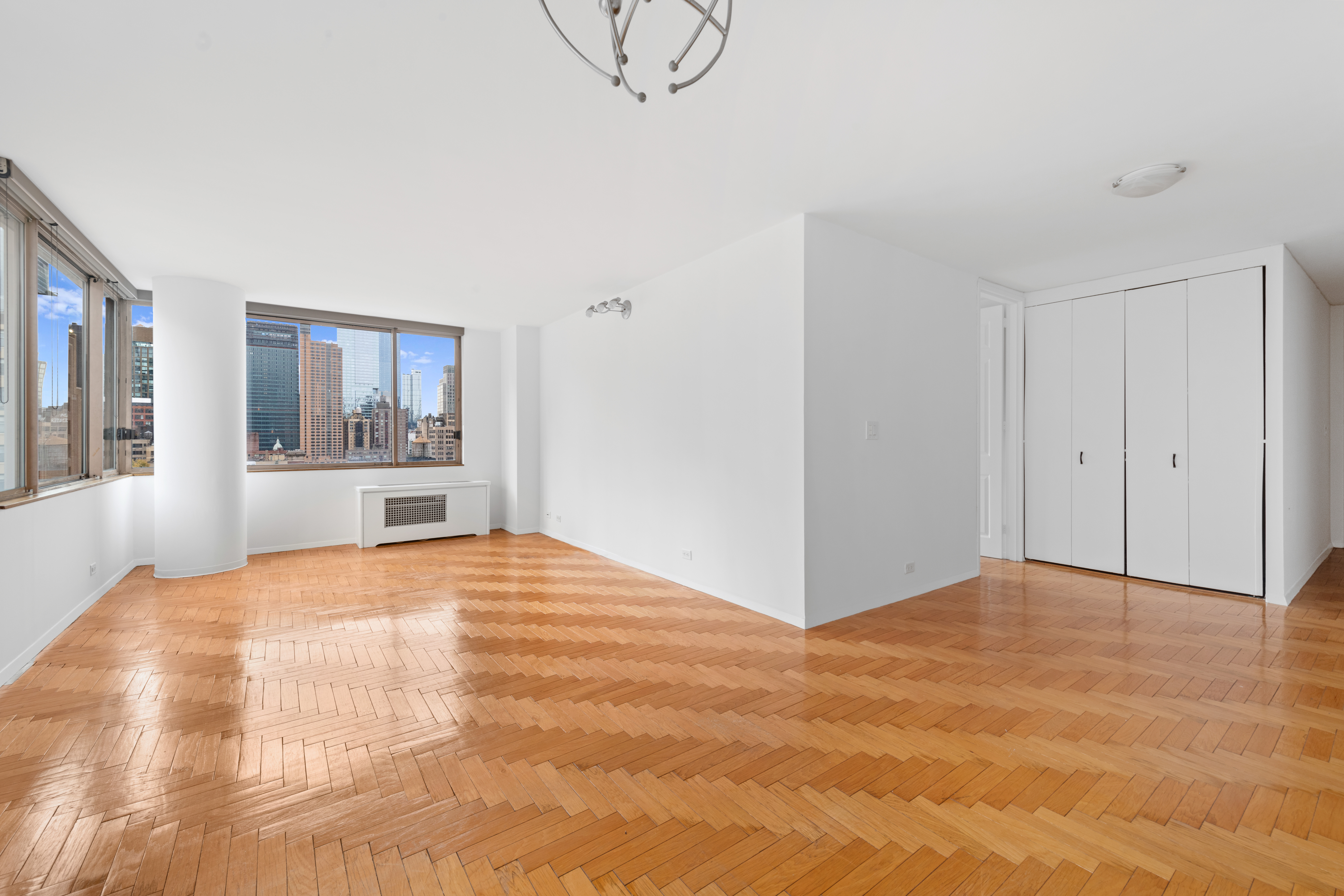350 West 50th Street, Unit 12B Manhattan, NY 10019 - Photo 3 of 16 a view of a livingroom with wooden floor and a kitchen