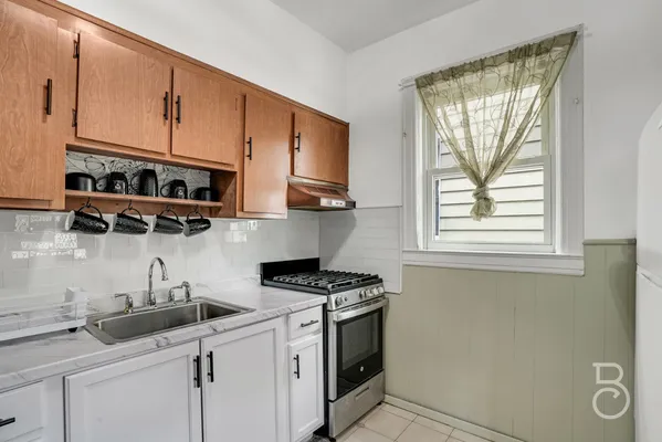a kitchen with stainless steel appliances white cabinets and a stove top oven