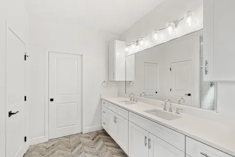 a spacious bathroom with double sink a mirror and a shower