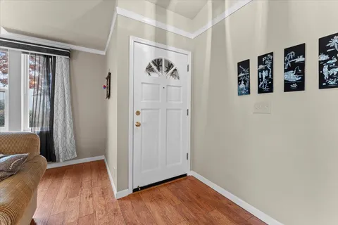 a view of a hallway with wooden floor and closet