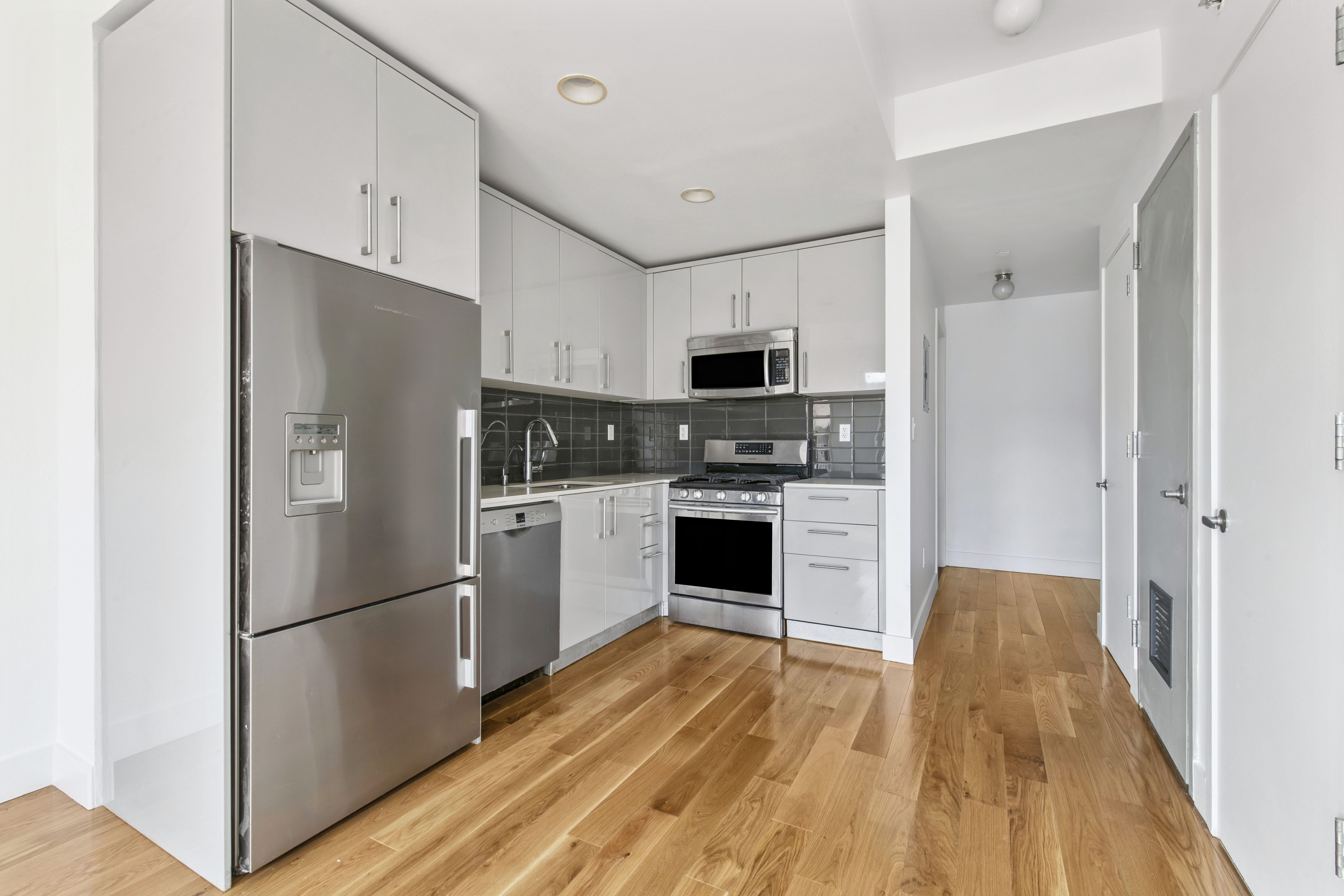 139 Skillman Avenue, Unit 4B Brooklyn, NY 11211 - Photo 6 of 19 a kitchen with cabinets stainless steel appliances and wooden floor