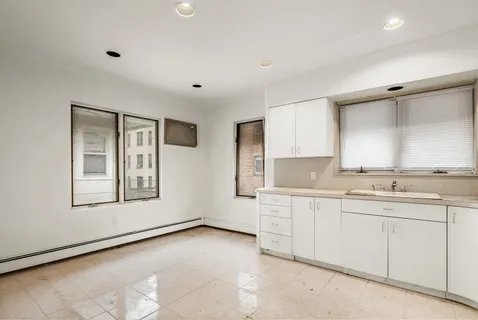 a large white room with double vanity sink and window