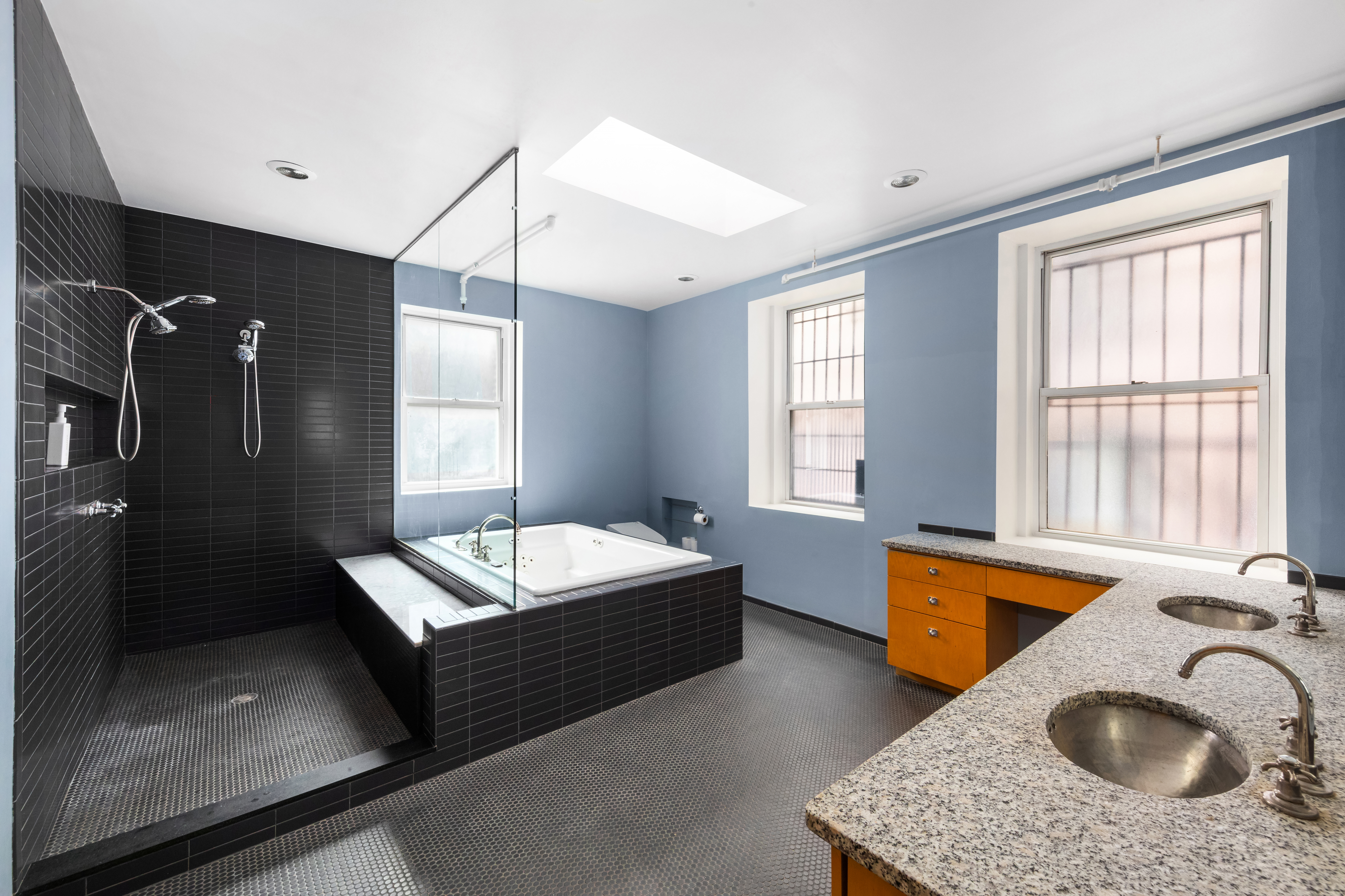253 West 28th Street, Unit 5 Manhattan, NY 10001 - Photo 10 of 19 a spacious bathroom with a tub sink and mirror