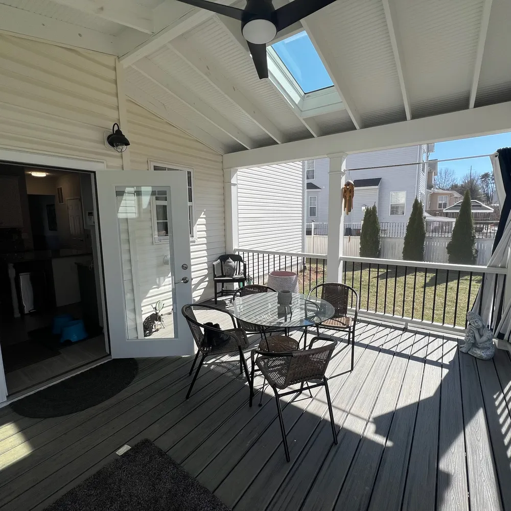 a view of a porch with furniture and wooden floor