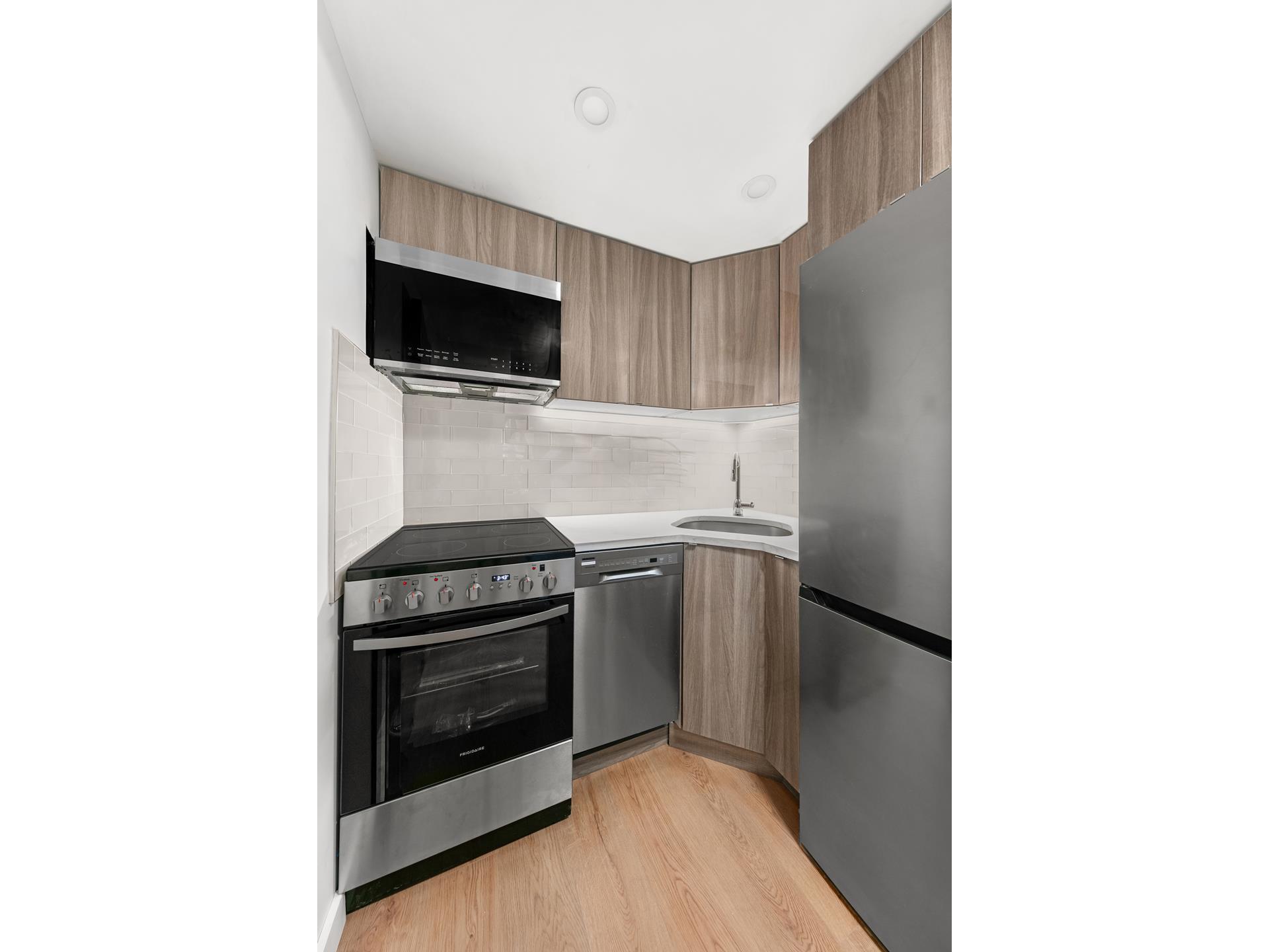 227 East 21st Street, Unit 2F Manhattan, NY 10010 - Photo 5 of 7 a kitchen with a stove and a microwave