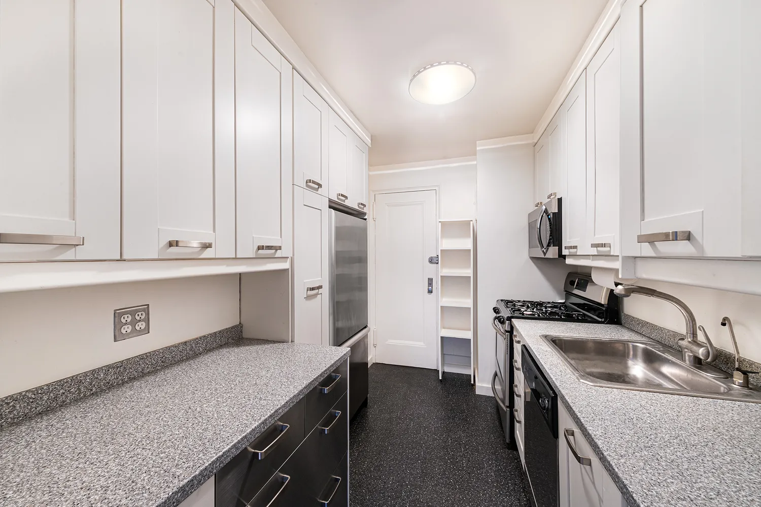 a kitchen with granite countertop a sink a stove and refrigerator