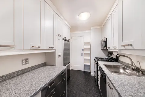 a kitchen with granite countertop a sink a stove and refrigerator