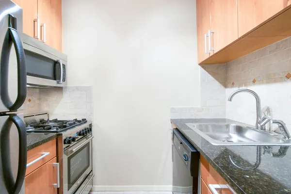 a kitchen with granite countertop a sink a stove and a microwave