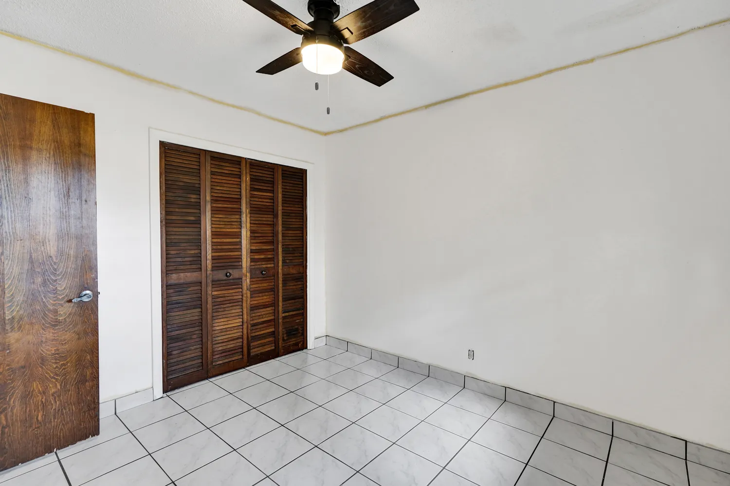 a view of an empty room with window and cabinet