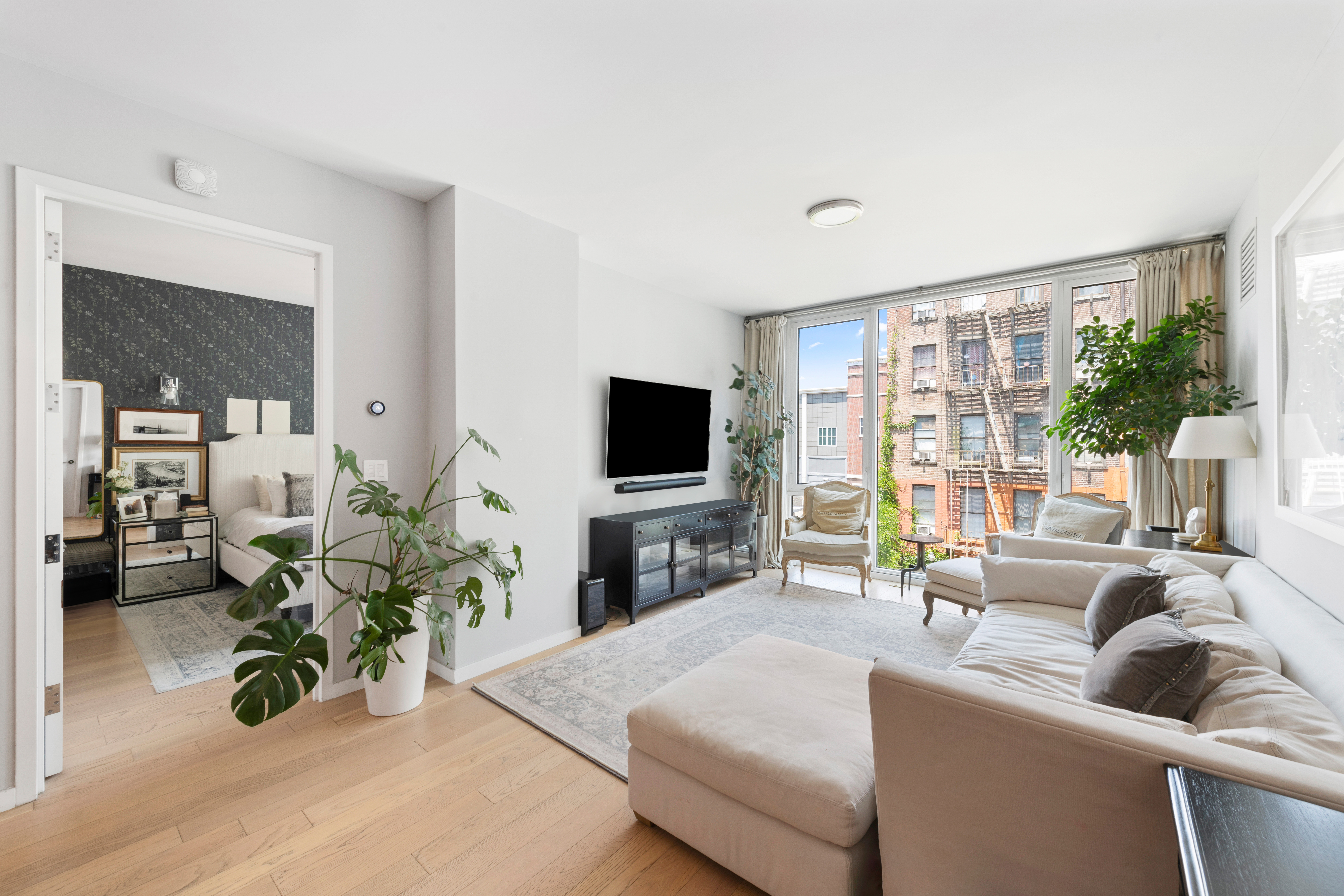 540 West 49th Street, Unit 401S Manhattan, NY 10019 - Photo 1 of 14 a living room with furniture a flat screen tv and a large window