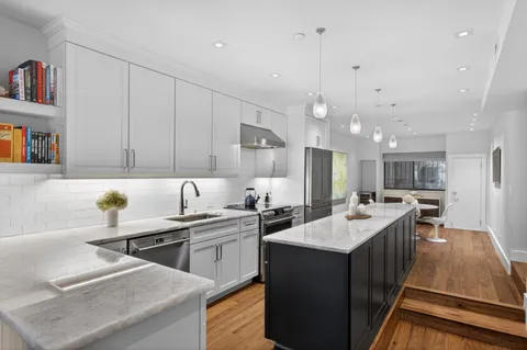 a kitchen with lots of counter space a sink appliances and cabinets
