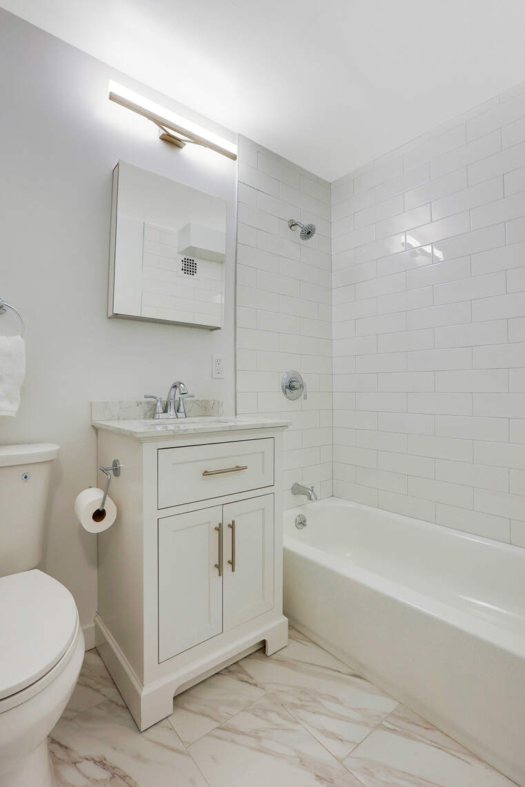 237 East 17th Street, Unit 520 Manhattan, NY 10003 - Photo 11 of 14 a bathroom with a tub sink toilet and mirror