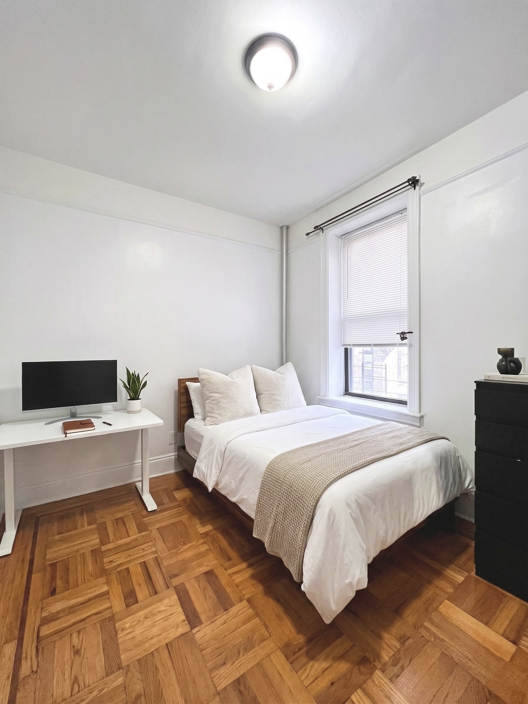 90 Thompson Street, Unit A2 Manhattan, NY 10012 - Photo 3 of 6 a spacious bedroom with a bed and a computer on the desk next to a window