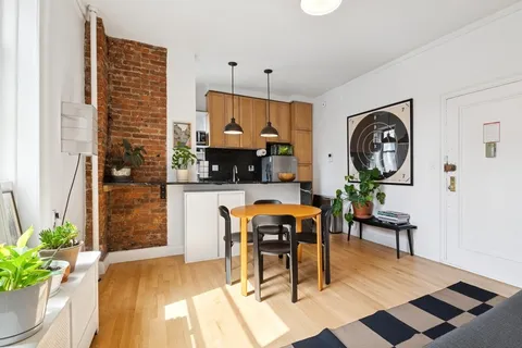 a living room with furniture a rug and white walls