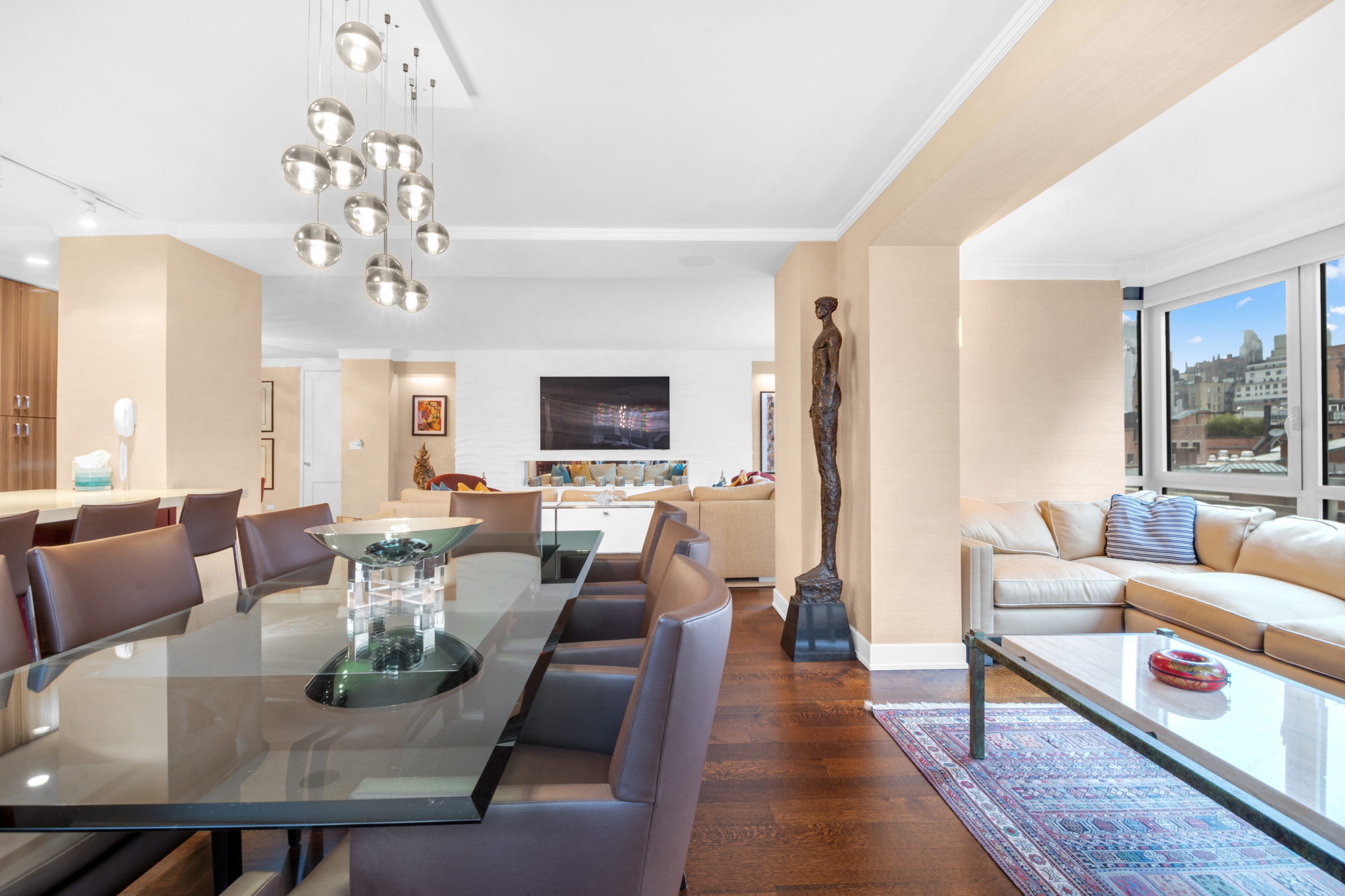 150 East 69th Street, Unit 6Q Manhattan, NY 10021 - Photo 4 of 15 a living room with furniture a chandelier and a dining table
