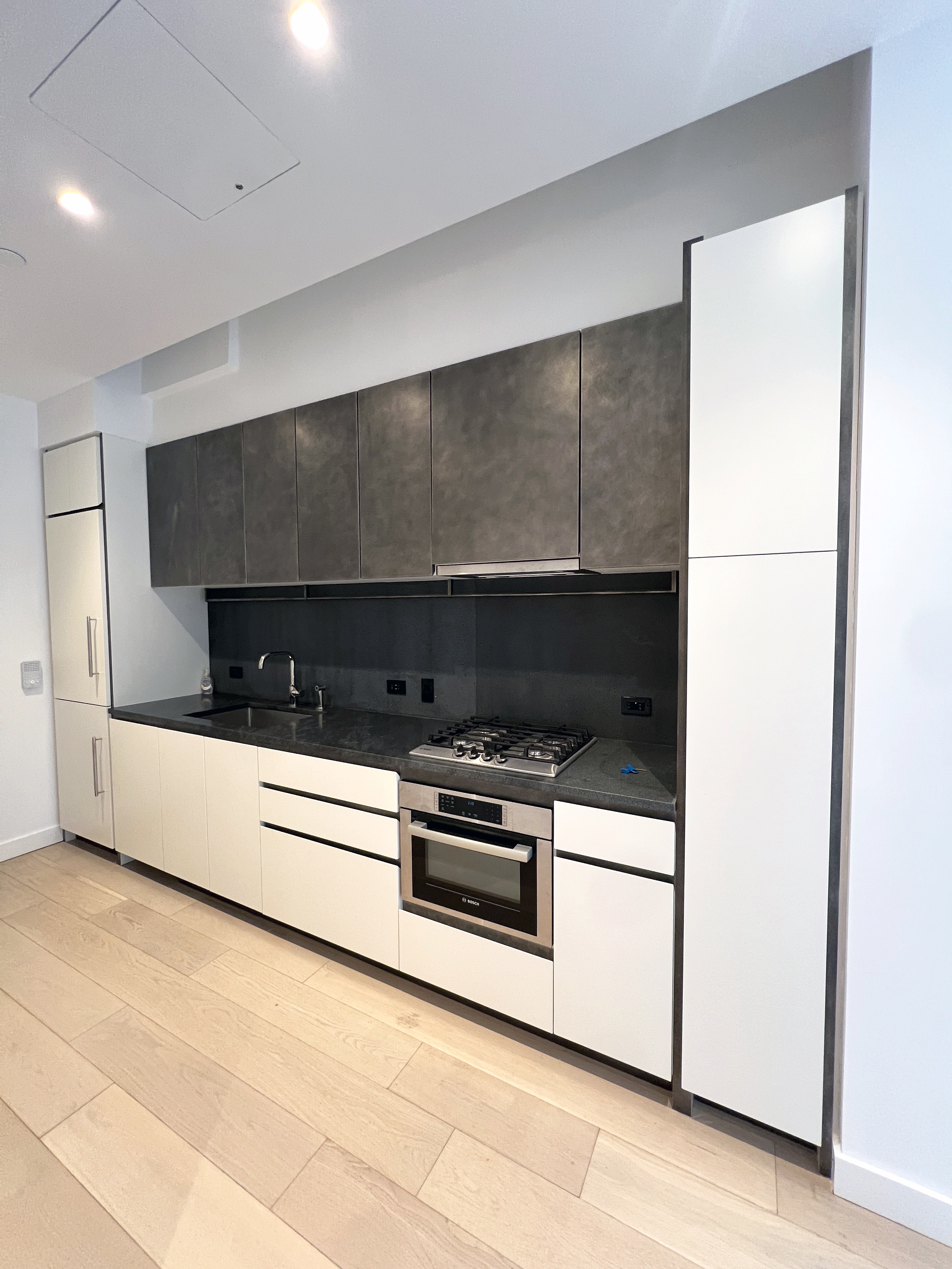 11 Hoyt Street, Unit 10M Brooklyn, NY 11201 - Photo 5 of 24 a kitchen with stainless steel appliances a stove and white cabinet