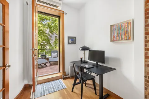a view of a workspace with furniture and a window
