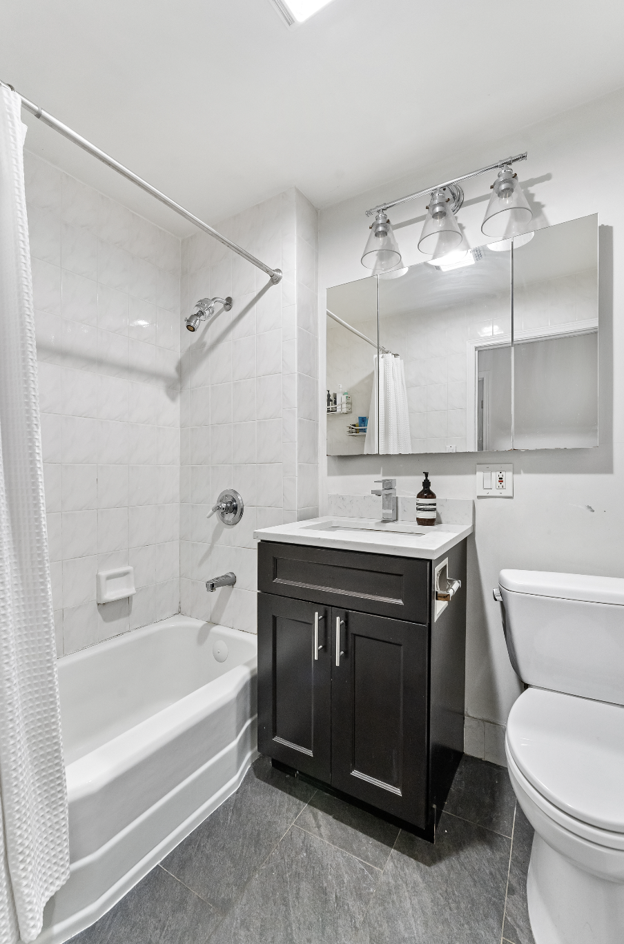 355 West 20th Street, Unit 1 Manhattan, NY 10011 - Photo 8 of 9 a spacious bathroom with a bathtub shower sink vanity and toilet