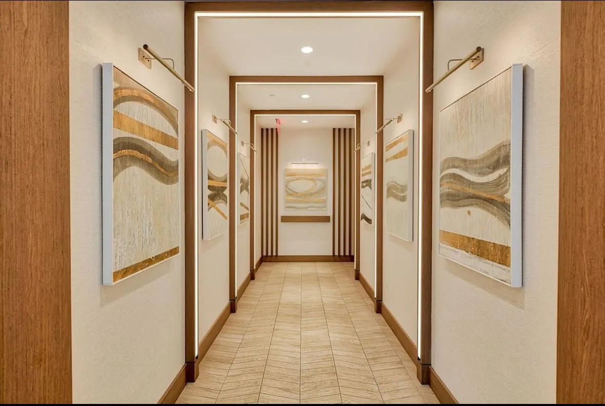 a view of a hallway with wooden floor and a door