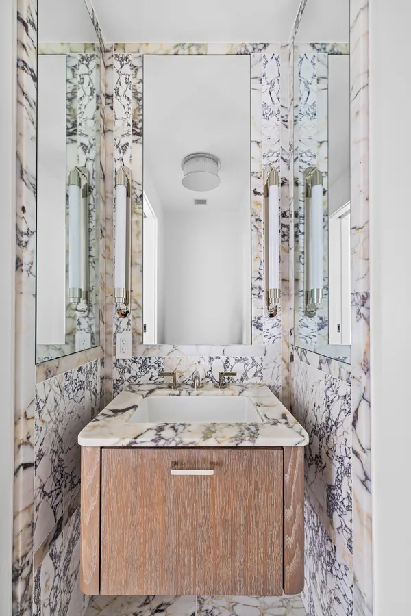 a bathroom with a granite countertop sink a mirror and shower