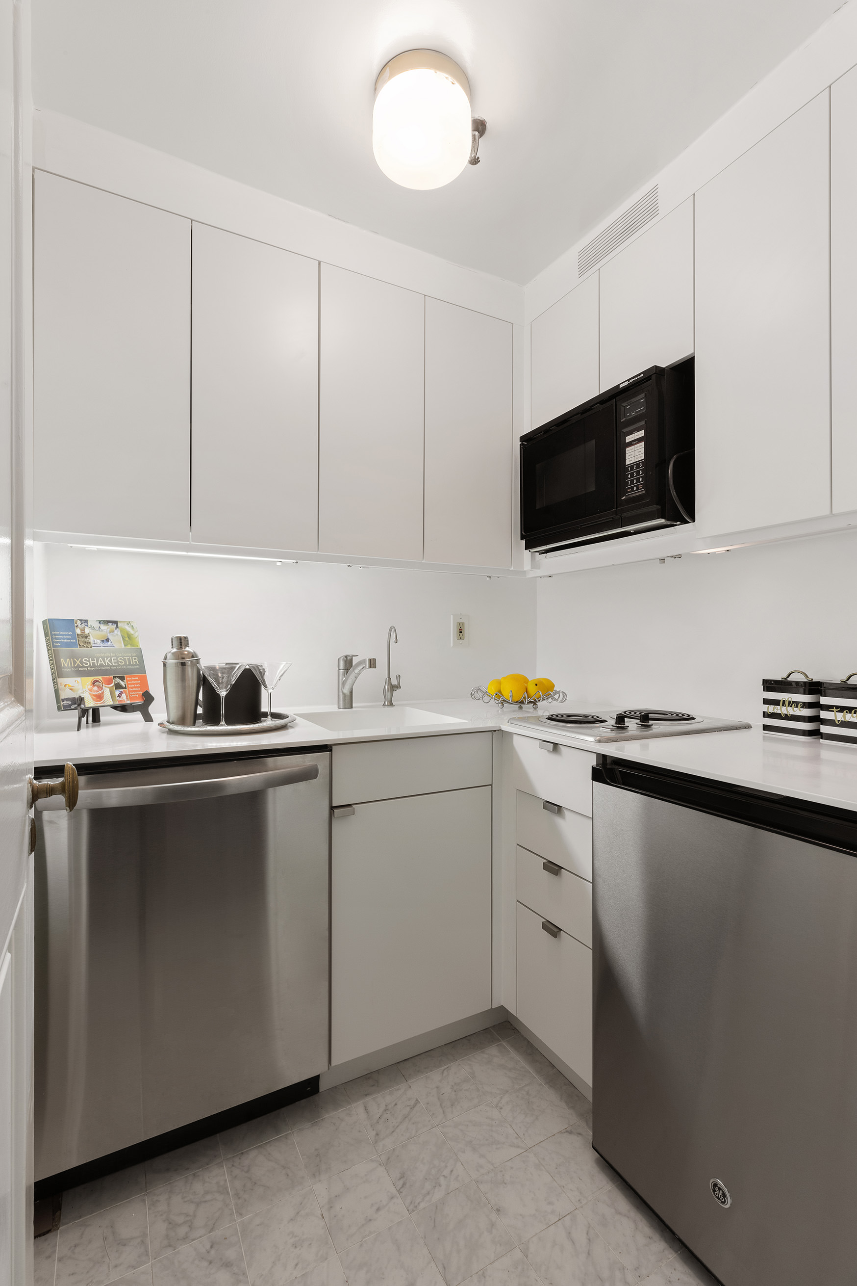 150 Central Park South, Unit 1010 Manhattan, NY 10019 - Photo 6 of 9 a kitchen with appliances cabinets and a sink