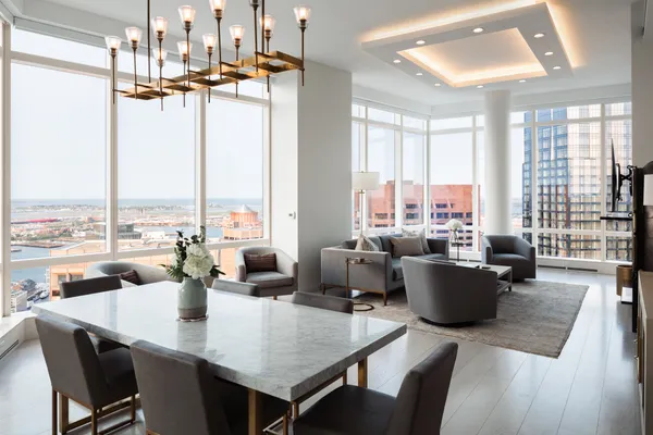 a dining room with wooden floor and large windows