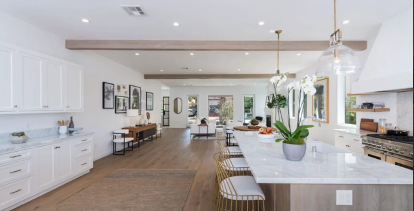 a living room with furniture kitchen view and a chandelier