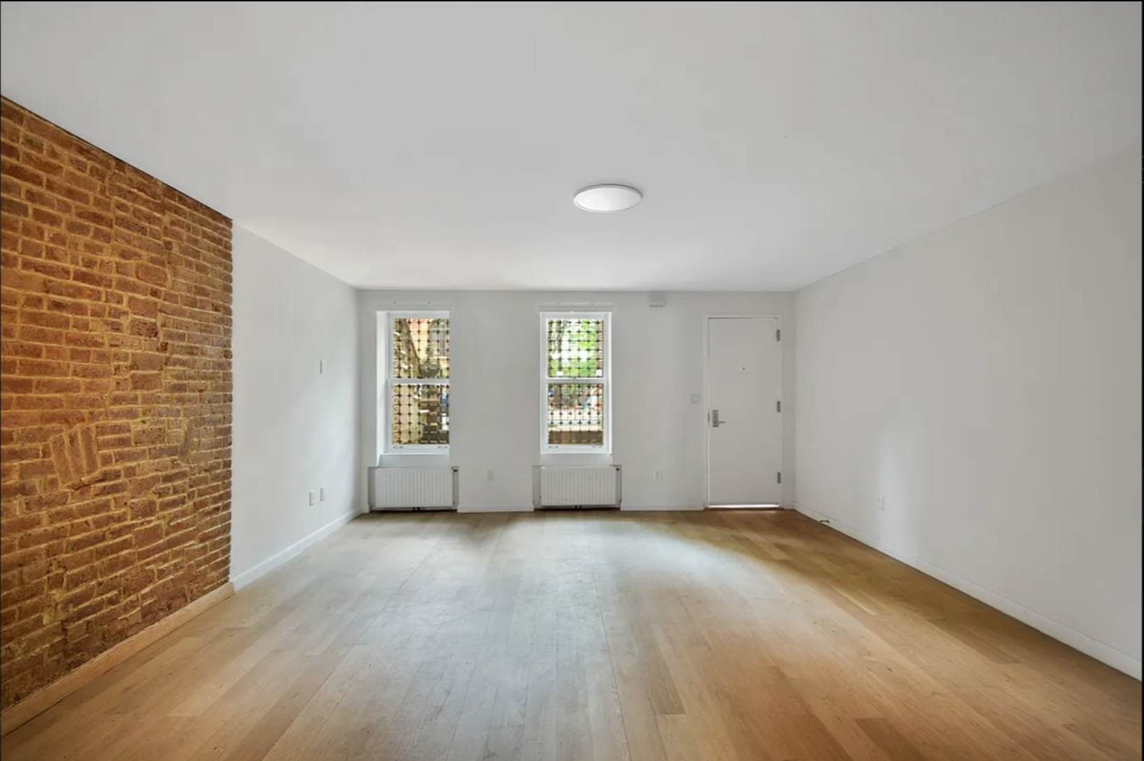430 East 140th Street, Unit 2 Bronx, NY 10454 - Photo 4 of 10 a view of an empty room with wooden floor and a window
