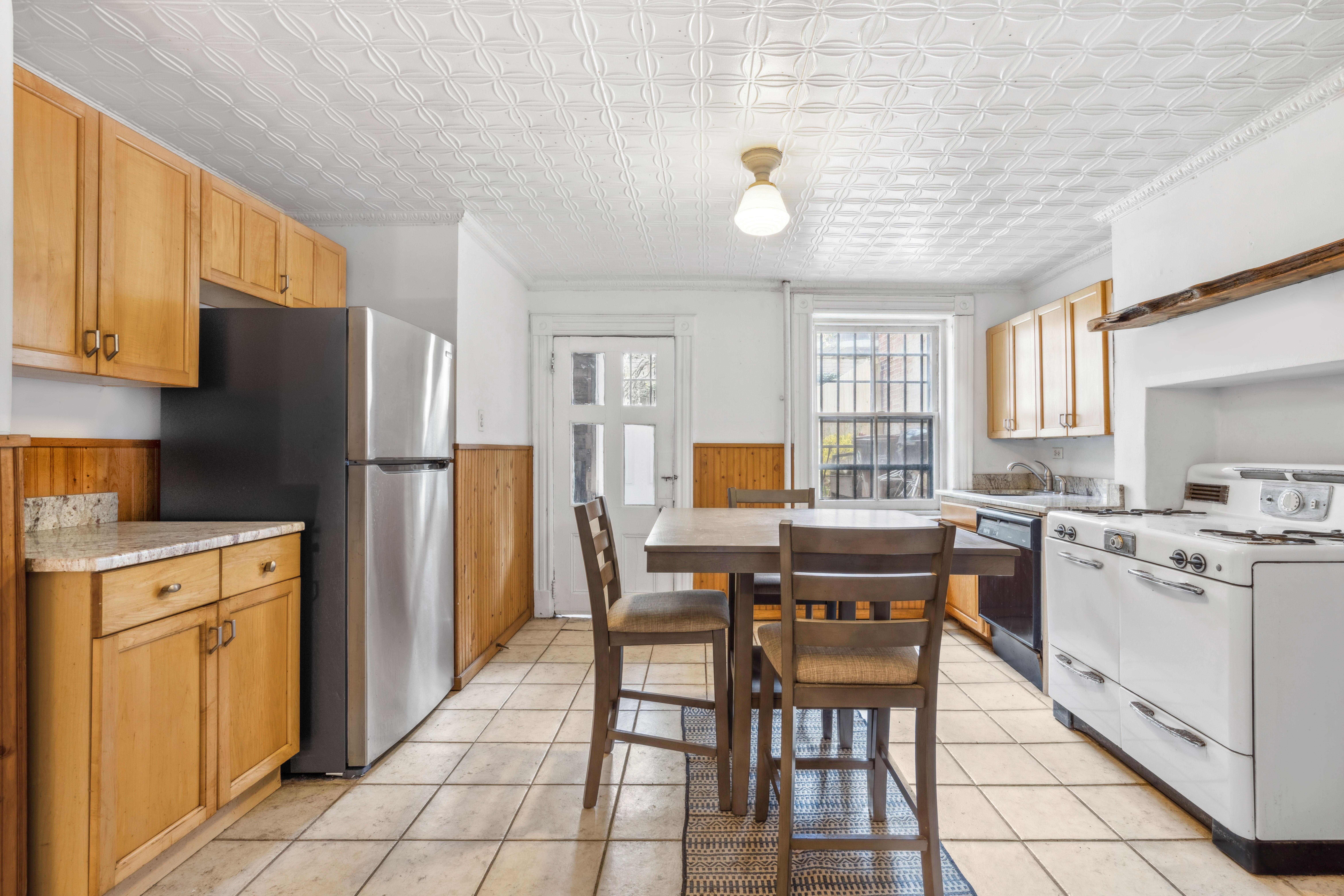 509 6th Avenue Brooklyn, NY 11215 - Photo 8 of 20 a kitchen with a stove a refrigerator and a dining table