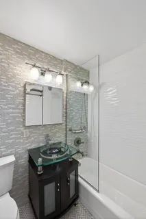 a bathroom with a granite countertop sink toilet and shower