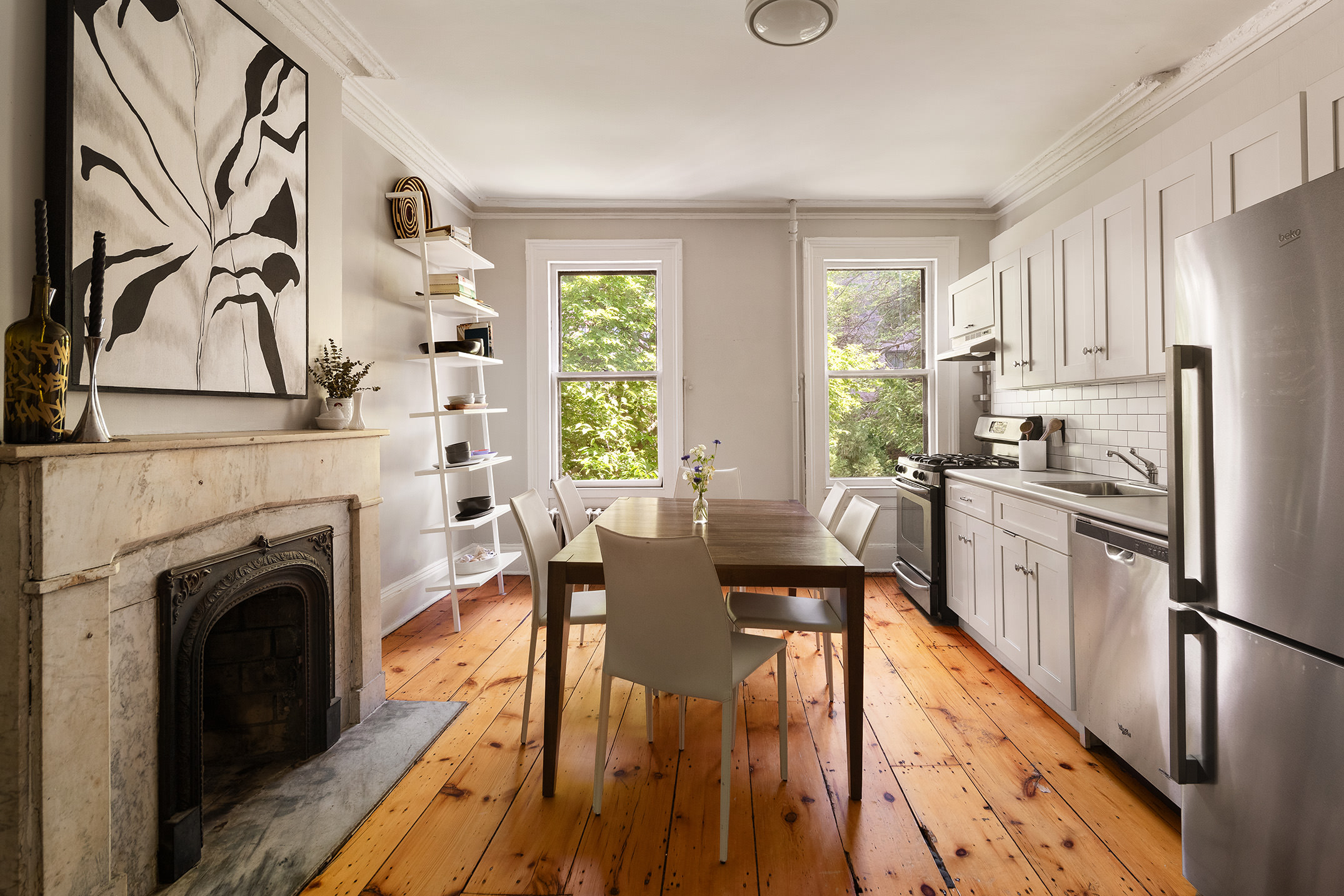 433 Pacific Street, Unit 2 Brooklyn, NY 11217 - Photo 2 of 7 a kitchen with stainless steel appliances kitchen island granite countertop a stove a refrigerator a dining table and chairs with wooden floor