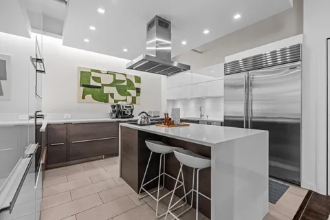 a kitchen with kitchen island a sink stainless steel appliances and cabinets