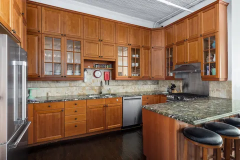 a kitchen with stainless steel appliances granite countertop a sink a stove and cabinets