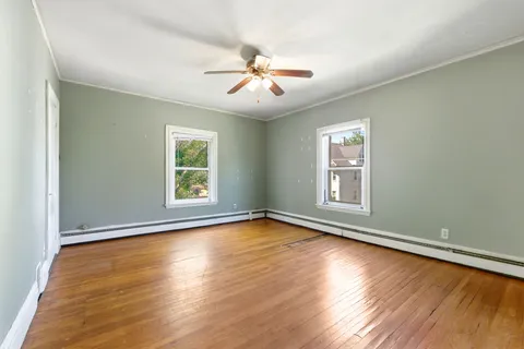a view of an empty room with wooden floor