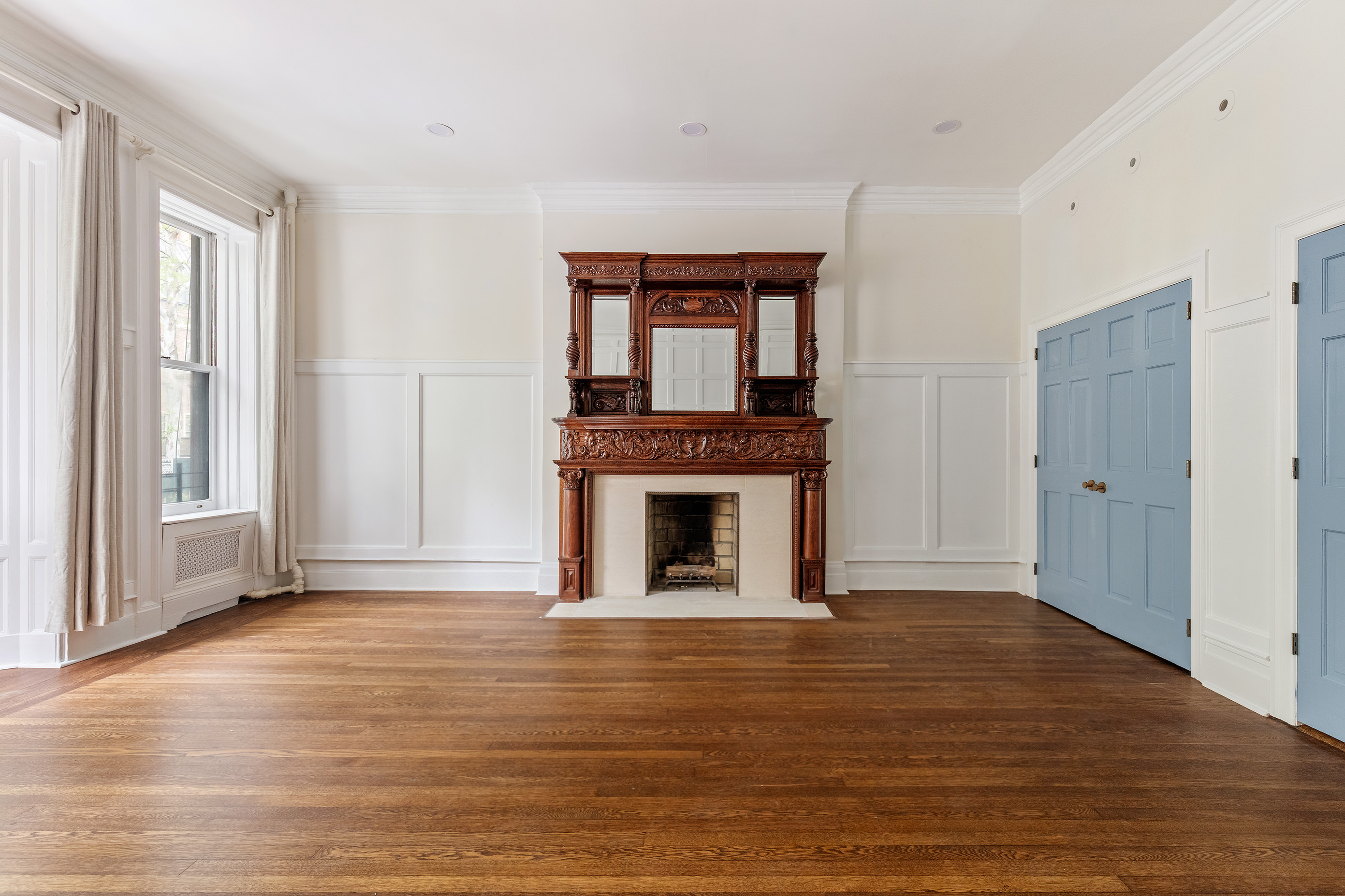 129 East 61st Street, Unit 3 Manhattan, NY 10065 - Photo 6 of 13 a view of a livingroom with wooden floor and a fireplace