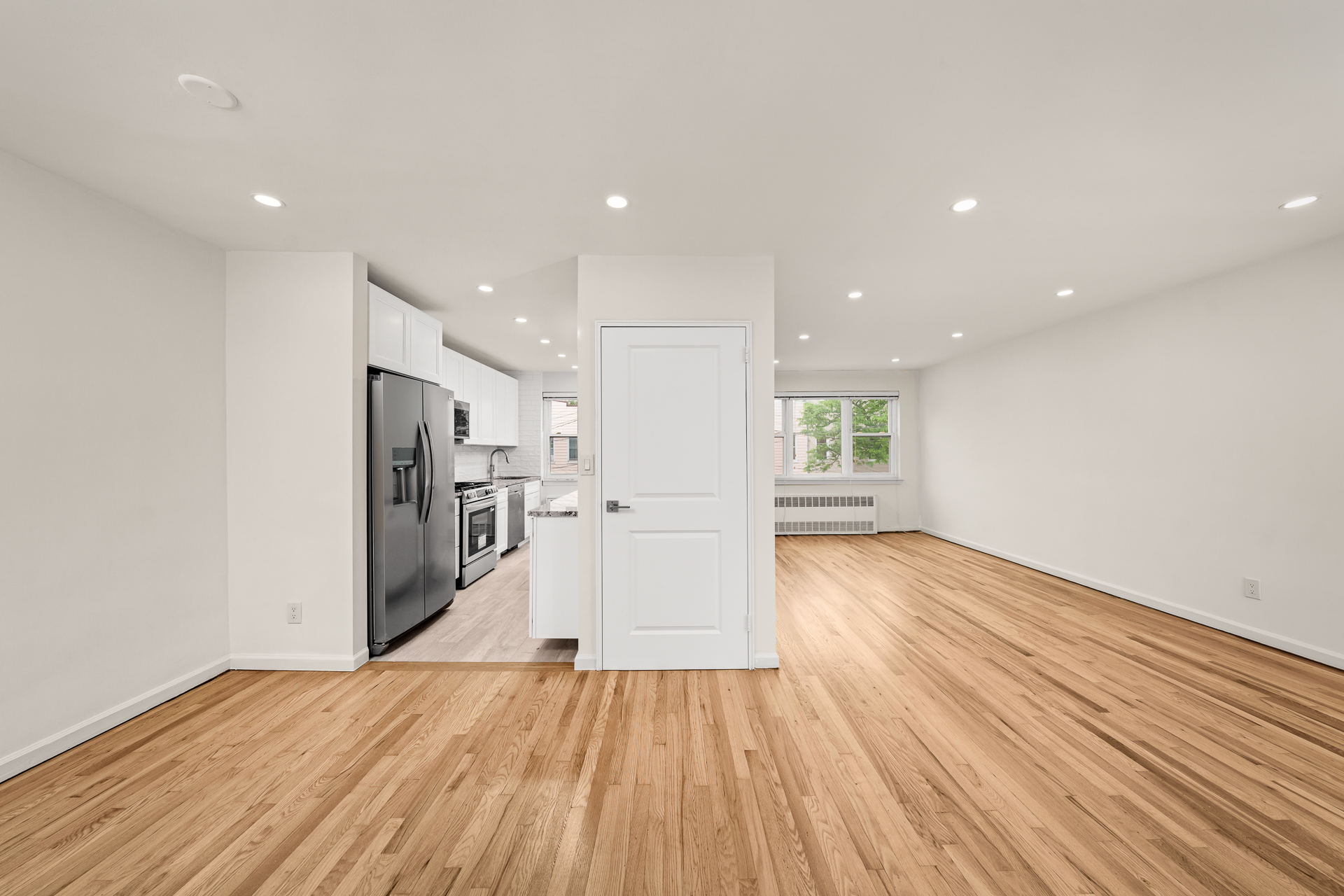a view of a kitchen with wooden floor and a refrigerator