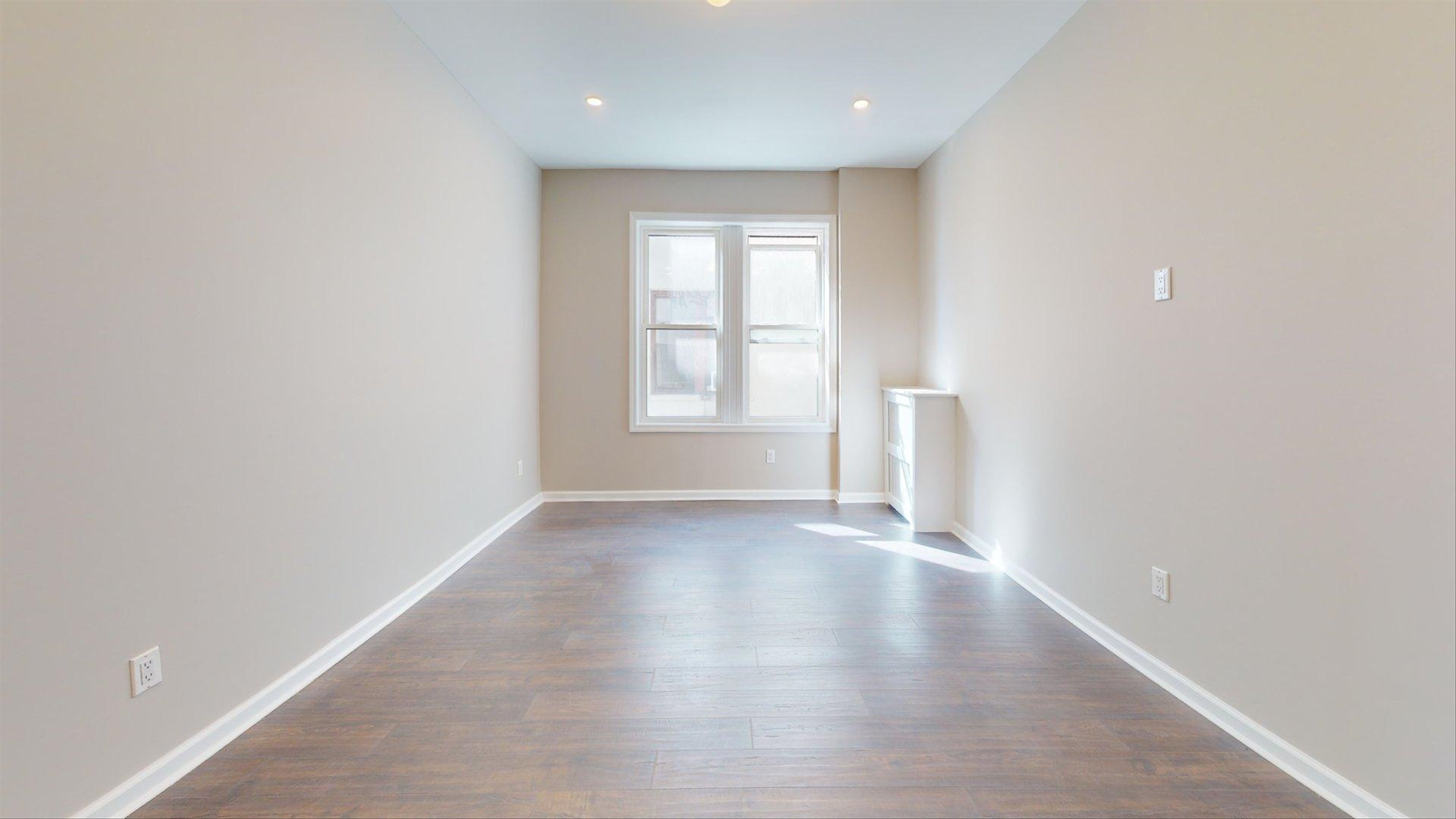 7609 4th Avenue, Unit E14 Brooklyn, NY 11209 - Photo 8 of 15 an empty room with wooden floor and windows