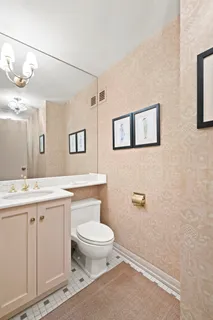 a bathroom with a granite countertop toilet sink and mirror