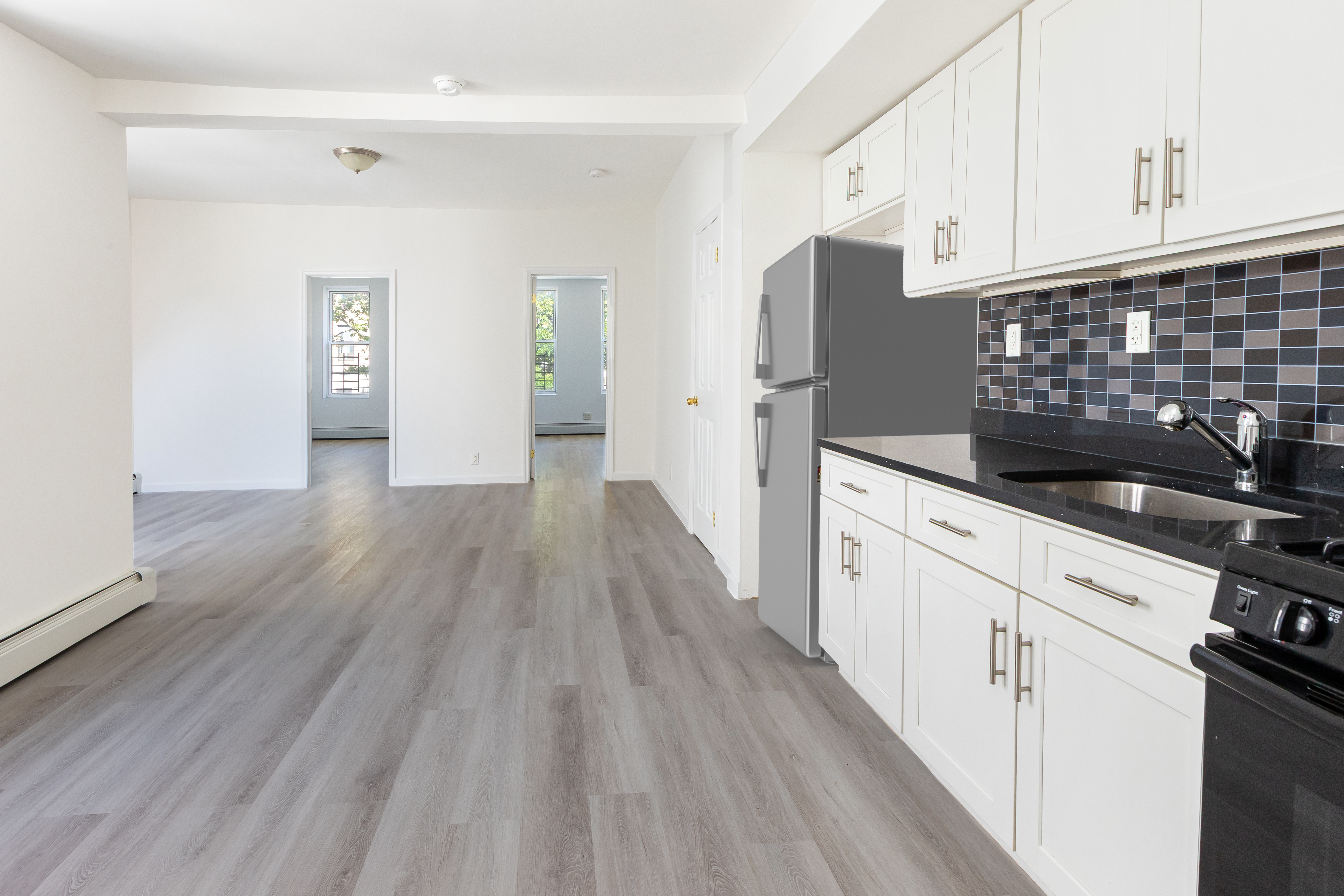 1030 Winthrop Street, Unit 2A Brooklyn, NY 11212 - Photo 3 of 10 a kitchen with granite countertop white cabinets and black appliances
