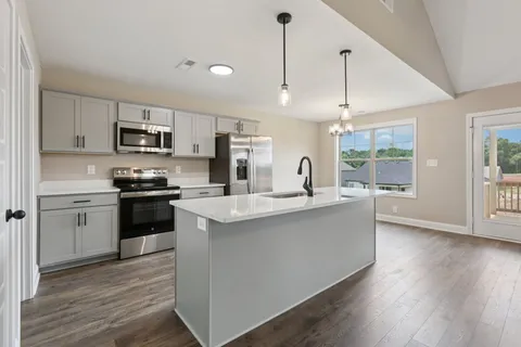 a kitchen with kitchen island white cabinets and stainless steel appliances
