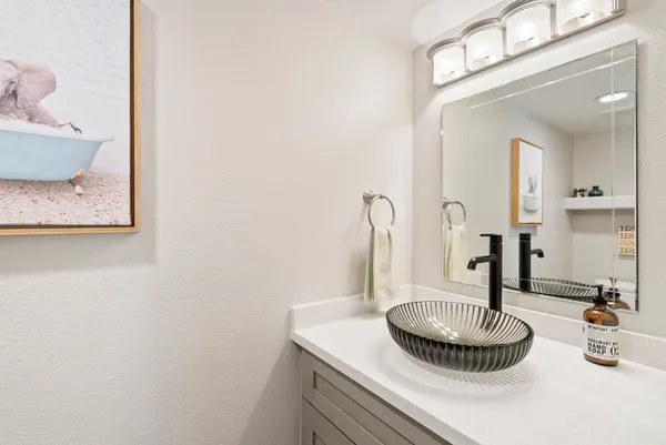 a bathroom with a granite countertop sink and a mirror