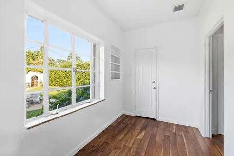a view of a room with wooden floor and windows