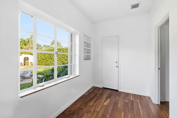 a view of a room with wooden floor and windows