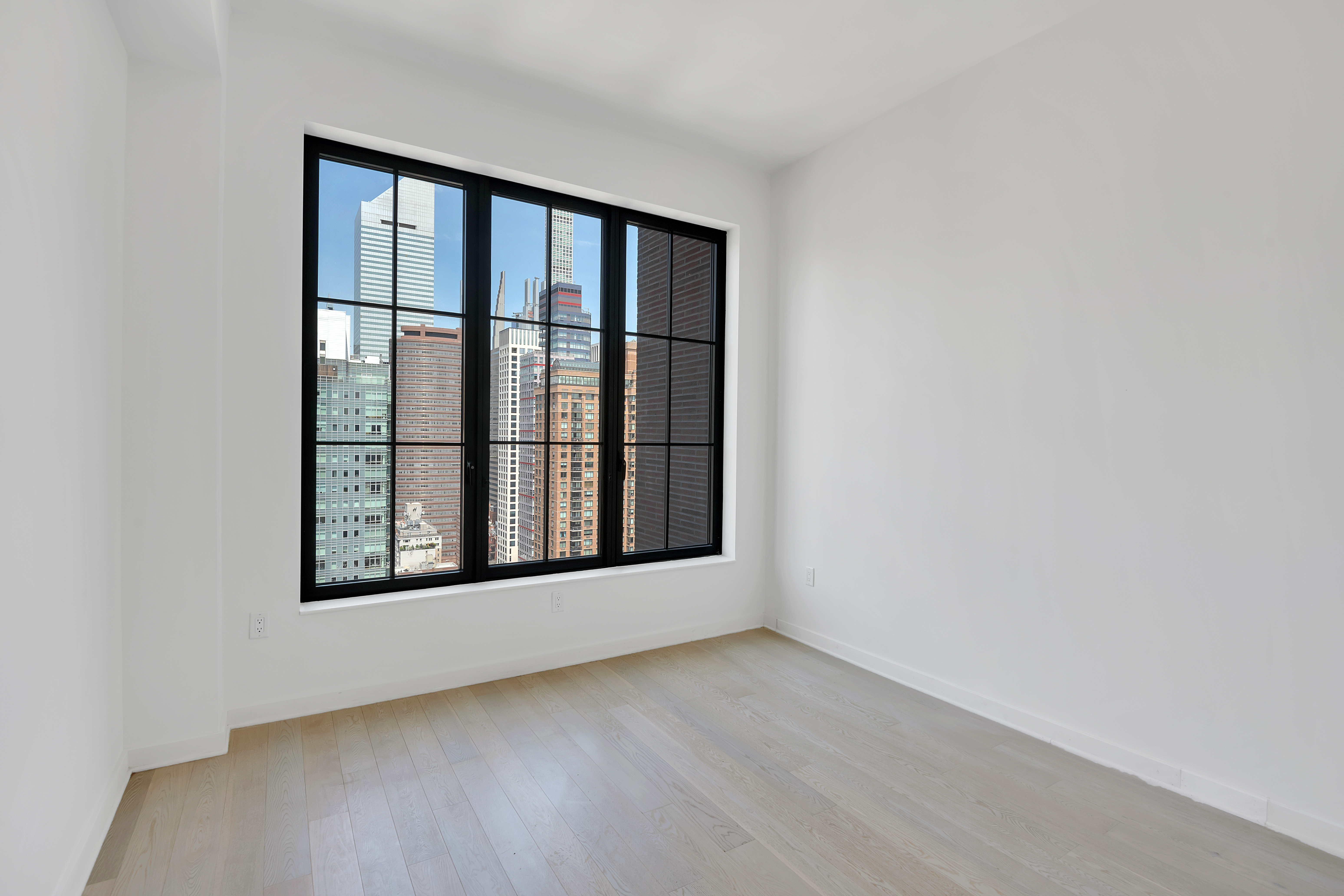 959 1st Avenue, Unit 25H Manhattan, NY 10022 - Photo 10 of 18 an empty room with wooden floor and windows