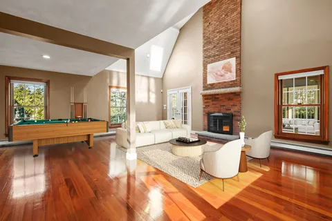 a living room with fireplace furniture and a large window