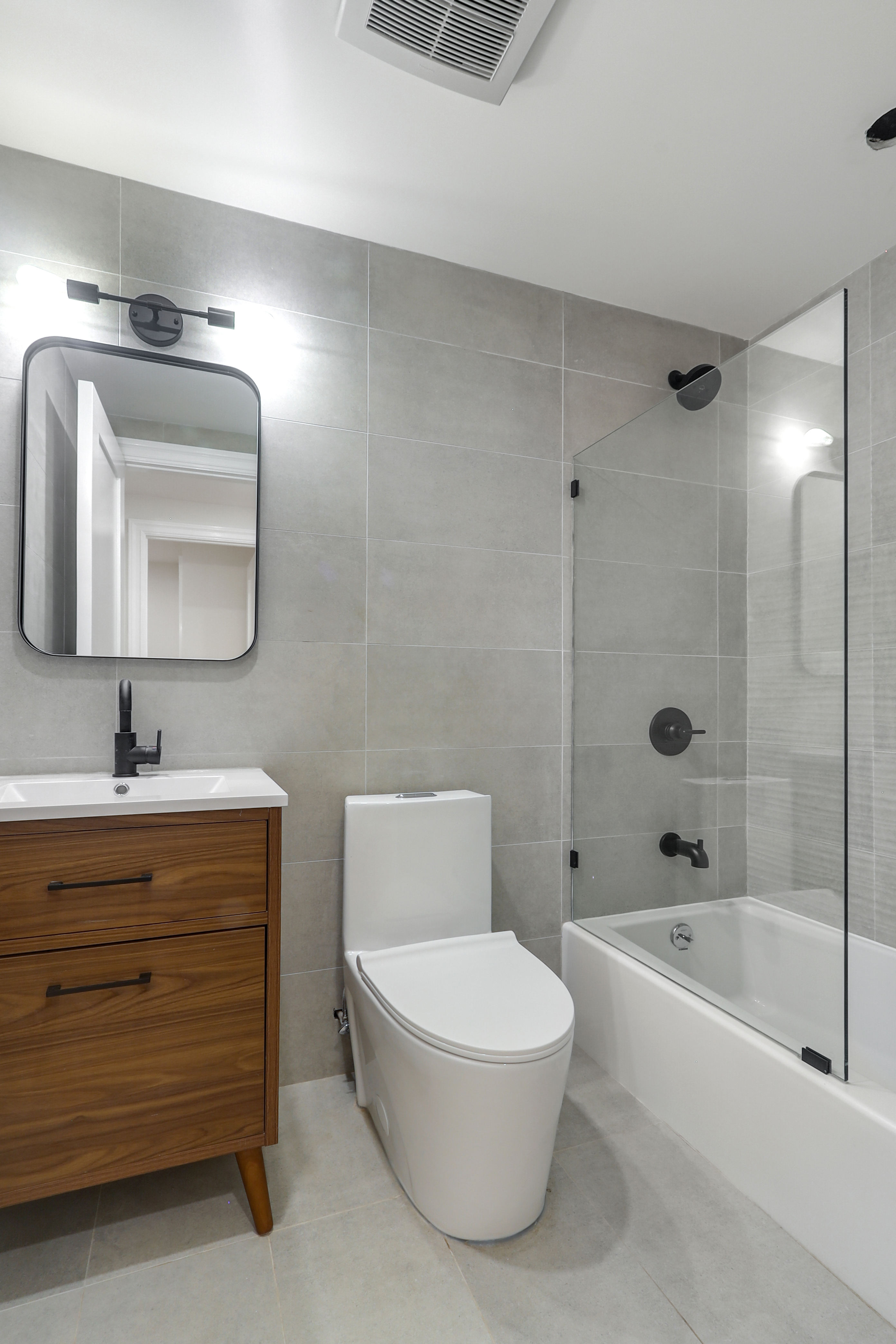 220 Lewis Avenue Brooklyn, NY 11221 - Photo 20 of 22 a bathroom with a toilet a sink a mirror and bathtub
