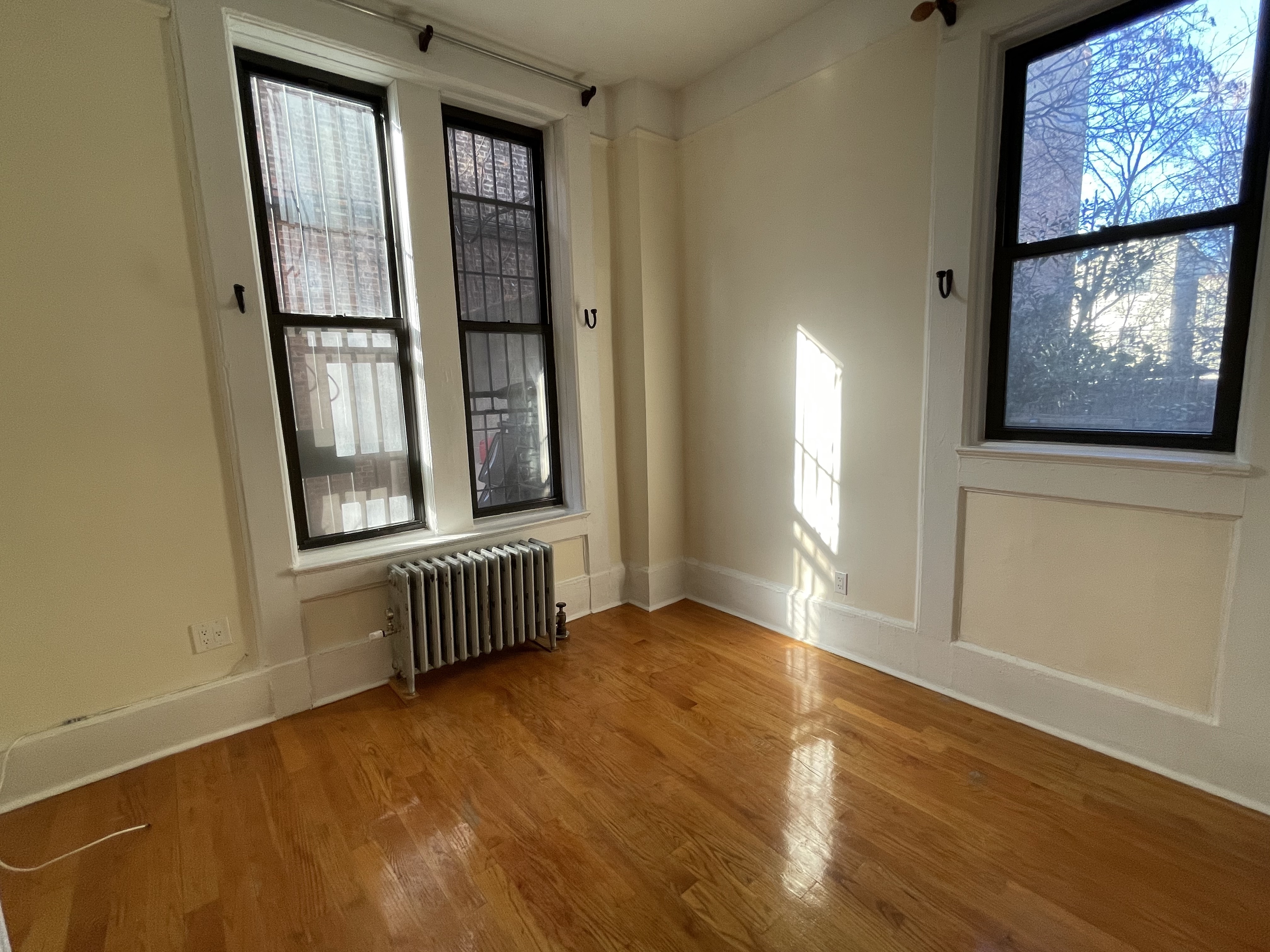 357 Sterling Place, Unit A2 Brooklyn, NY 11238 - Photo 3 of 8 an empty room with wooden floor and windows