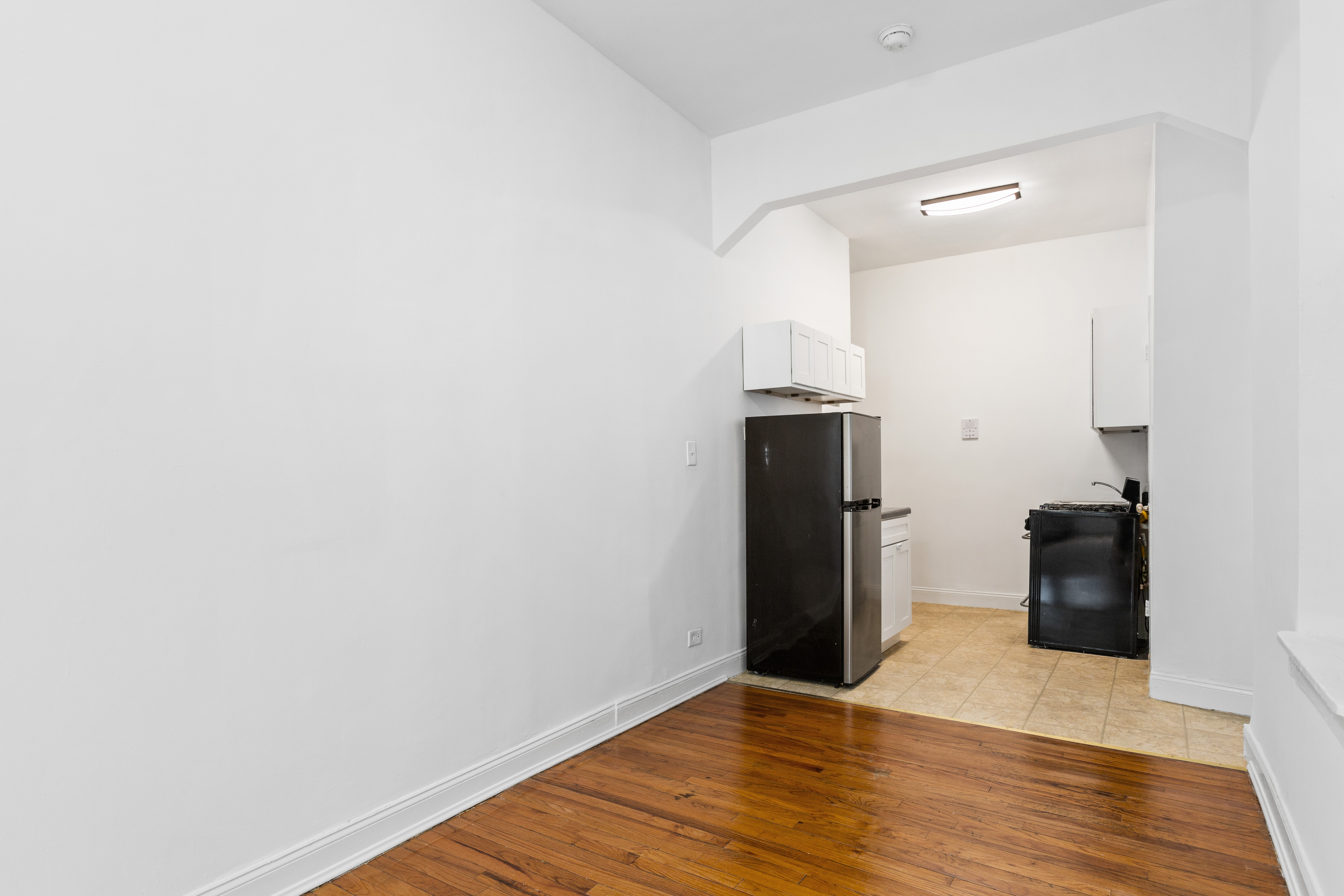 1775 Madison Avenue, Unit 1A Manhattan, NY 10035 - Photo 3 of 10 a view of a kitchen with refrigerator and wooden floor