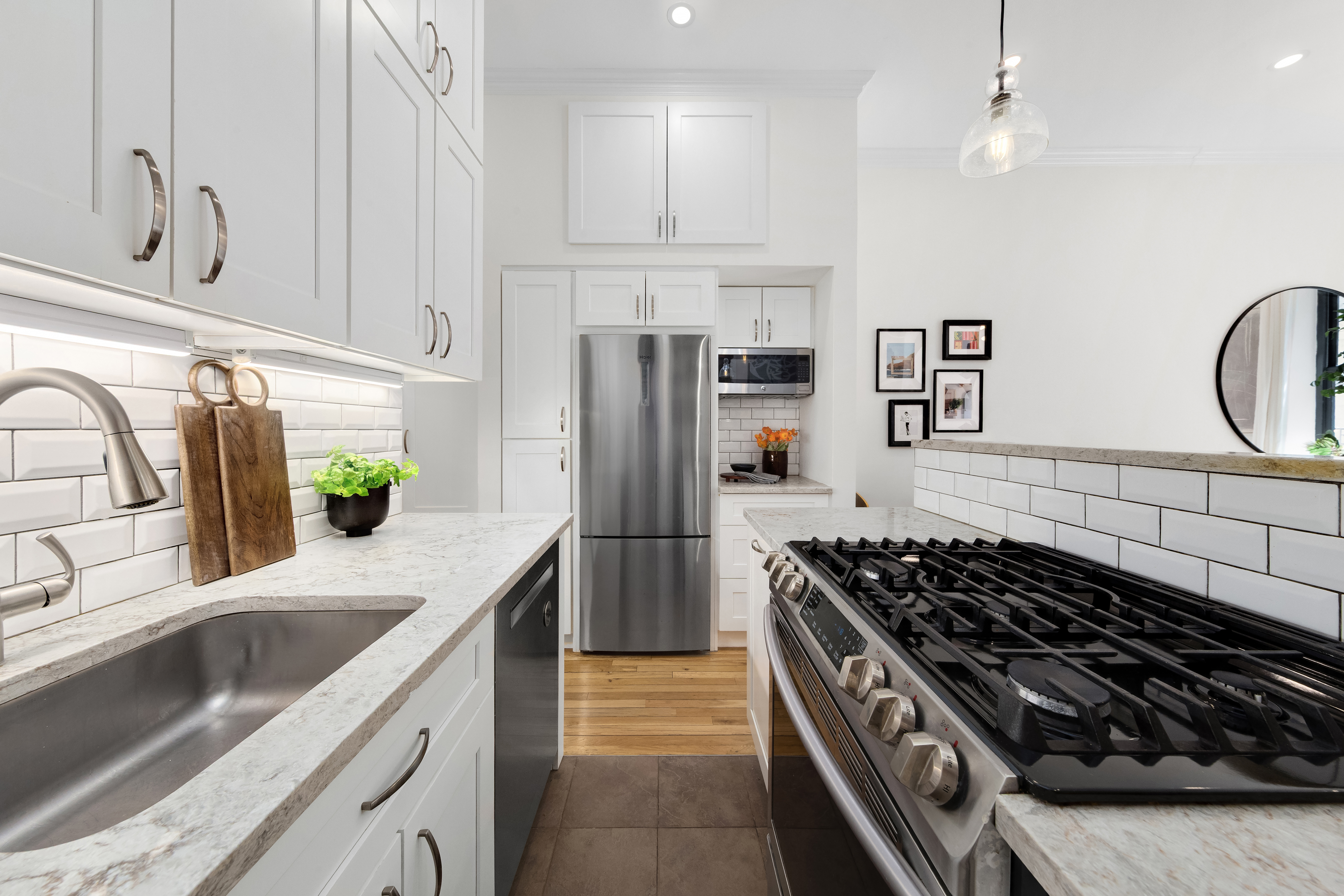 170 East 92nd Street, Unit 1D Manhattan, NY 10128 - Photo 5 of 12 a kitchen with granite countertop a stove sink and refrigerator