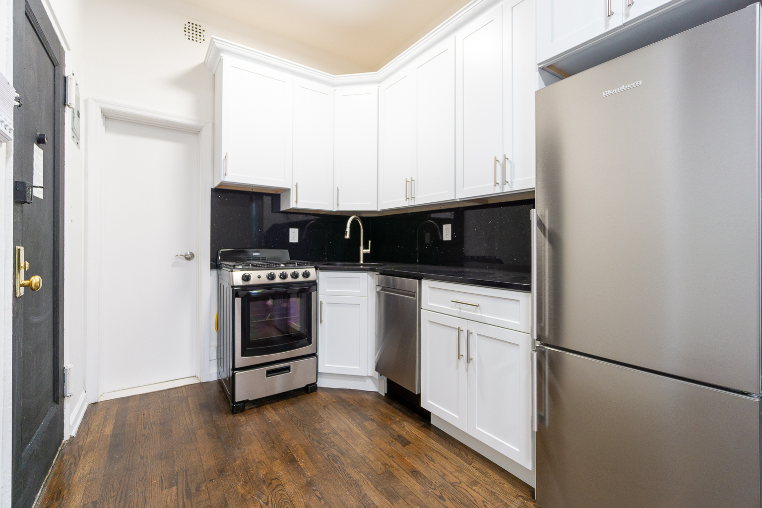339 East 6th Street, Unit B Manhattan, NY 10003 - Photo 14 of 22 a kitchen with white cabinets and white appliances